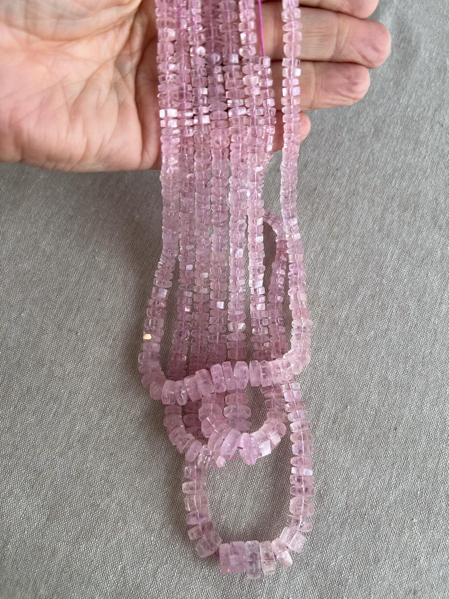 Close-up of Pink Morganite gemstone beads showing beautiful rosy pink color, transparency, and sparkling faceted bolt cuts. multiple strands