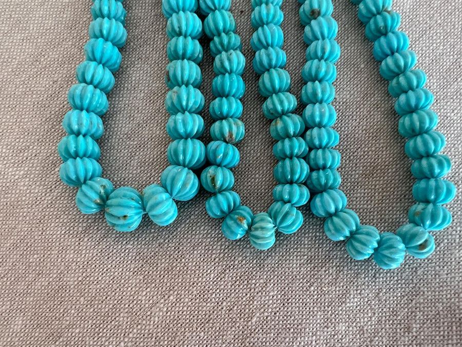 Natural untreated Arizona Sleeping Beauty Turquoise beads with hand-carved melon shapes, smooth polished surfaces, and blue color variations.