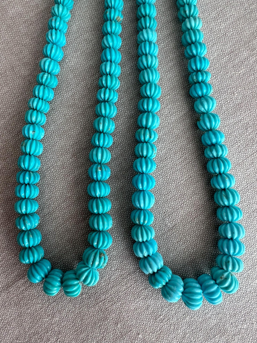 Natural untreated Sleeping Beauty Turquoise beads with distinctive carved pumpkin shapes, blue color, and contrasting brown matrix.
