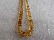 Close-up of AAA Citrine gemstone beads showing brilliant golden yellow color, excellent transparency, and sparkling hexagonal facets.