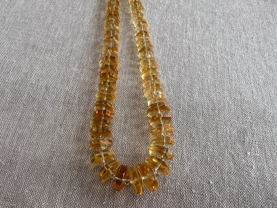 Close-up of AAA Citrine gemstone beads showing brilliant golden yellow color, excellent transparency, and sparkling hexagonal facets.
