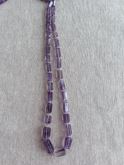 15-inch strand of AAA Brazilian Amethyst faceted cylinder gemstone beads, graduated from 5x10mm to 9x15mm.