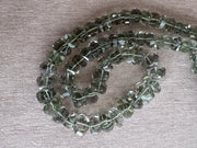 AAA green amethyst Prasiolite beads featuring unusual twisted rondelle shapes, transparent clarity, and consistent green color.