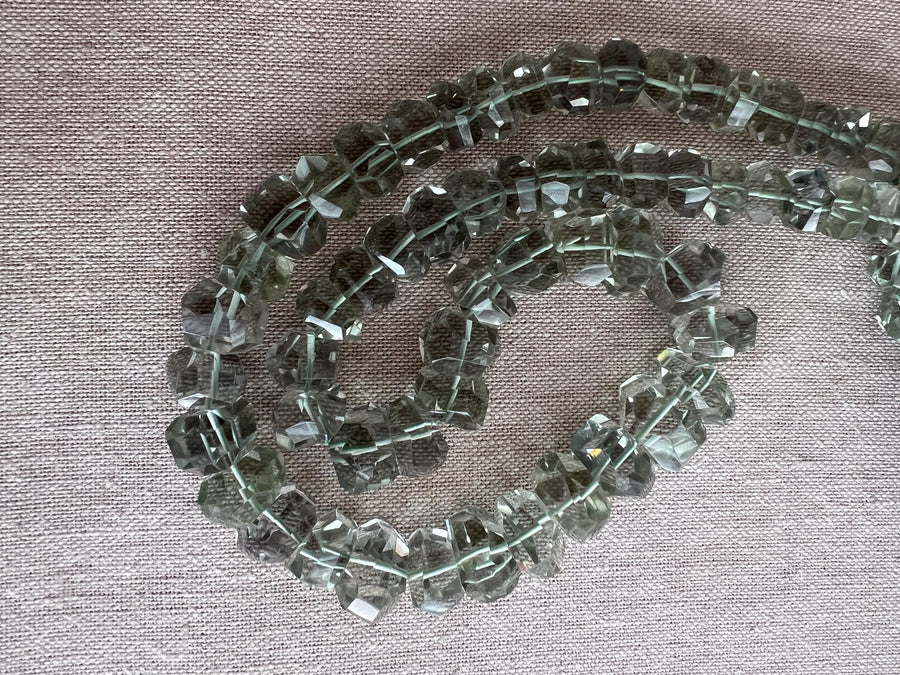 AAA green amethyst Prasiolite beads featuring unusual twisted rondelle shapes, transparent clarity, and consistent green color.