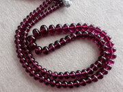 High-grade Rhodolite Garnet smooth rondelle gemstone beads in deep raspberry and plum tones for custom necklaces and fine jewelry designs.
