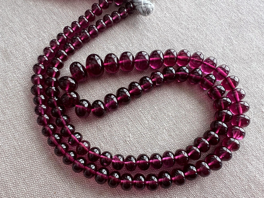 High-grade Rhodolite Garnet smooth rondelle gemstone beads in deep raspberry and plum tones for custom necklaces and fine jewelry designs.