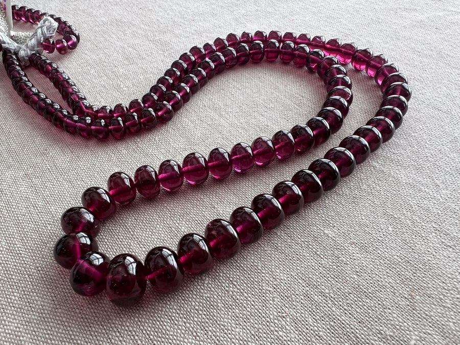 AAA+ natural Rhodolite Garnet smooth rondelle beads in rich pinkish-purple and plum shades, graduated from 6.5mm to 11mm.