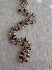 18-inch strand of mixed semi-precious faceted button beads, graduated from 7mm to 9.5mm, with approximately 60 gemstones.