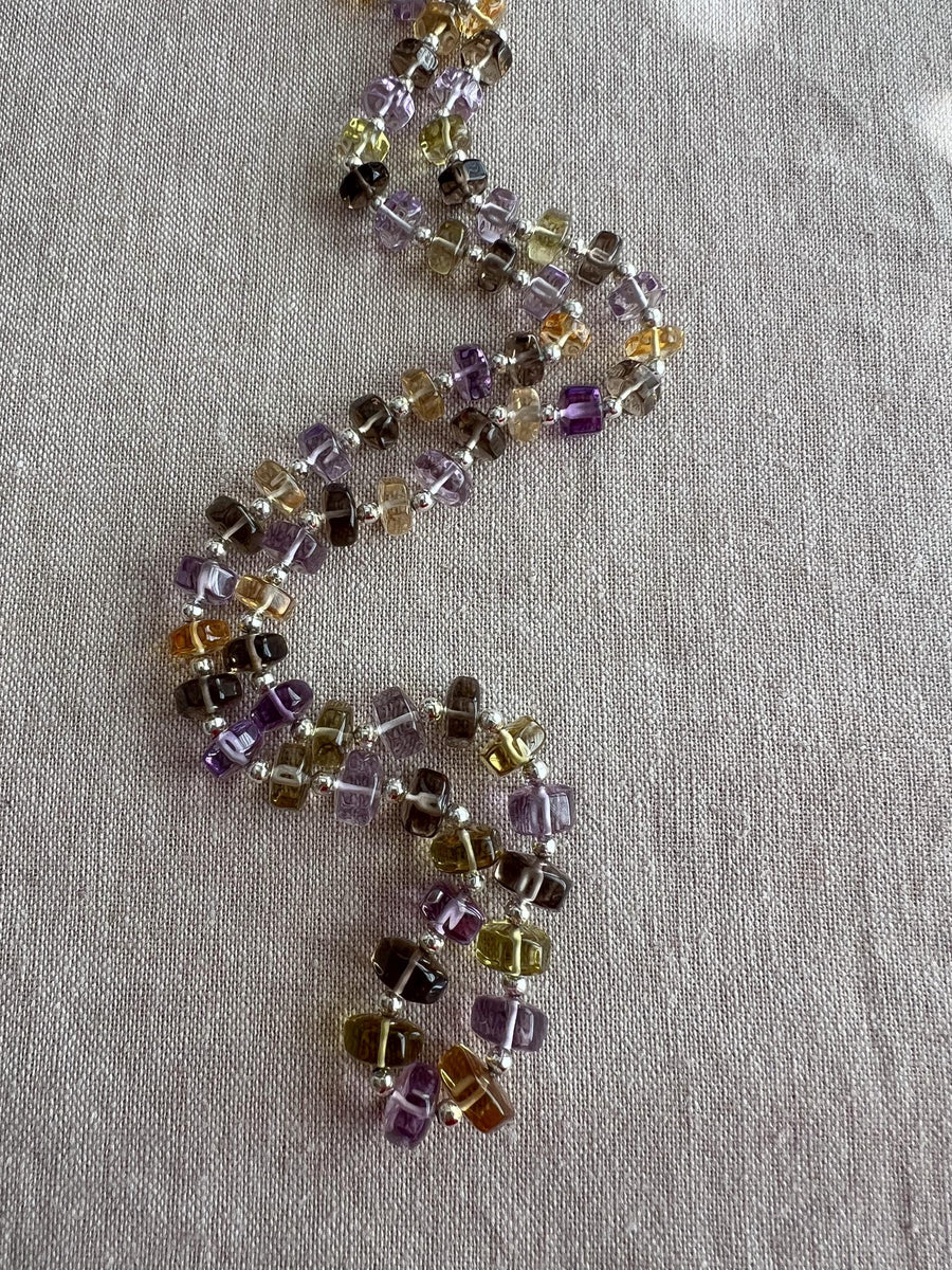 18-inch strand of mixed semi-precious faceted button beads, graduated from 7mm to 9.5mm, with approximately 60 gemstones.