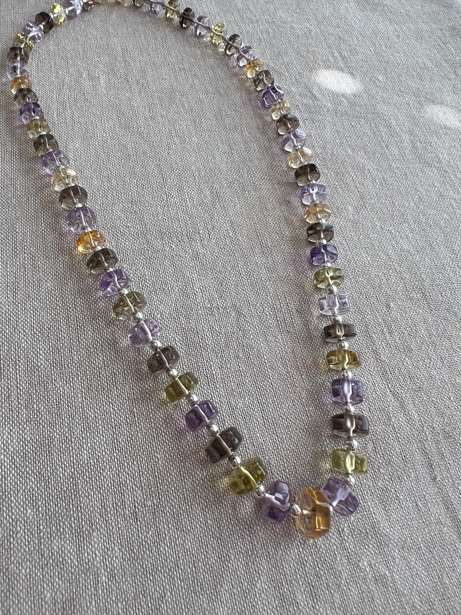 18-inch strand of mixed semi-precious faceted button beads, graduated from 7mm to 9.5mm, with approximately 60 gemstones.