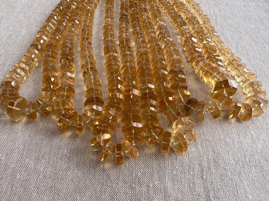 Close-up of AAA Citrine gemstone beads showing brilliant golden yellow color, excellent transparency, and sparkling hexagonal facets.