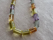 Faceted Amethyst, green Prasiolite, golden Citrine, and yellow Lemon Quartz cylinder beads in a vibrant multi-color gemstone mix.