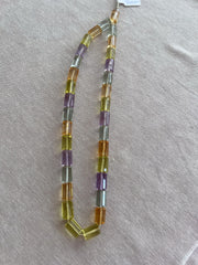 18-inch strand of mixed semi-precious faceted cylinder beads featuring 32 transparent gemstones in approximately 10x15mm sizes. orange, green, blue and purple gemstone beads