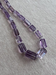 Transparent purple Amethyst gemstone beads with precision faceted cylinder cuts, beautiful clarity, and consistent violet color.