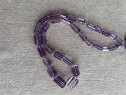15-inch strand of AAA Brazilian Amethyst faceted cylinder gemstone beads, graduated from 5x10mm to 9x15mm.