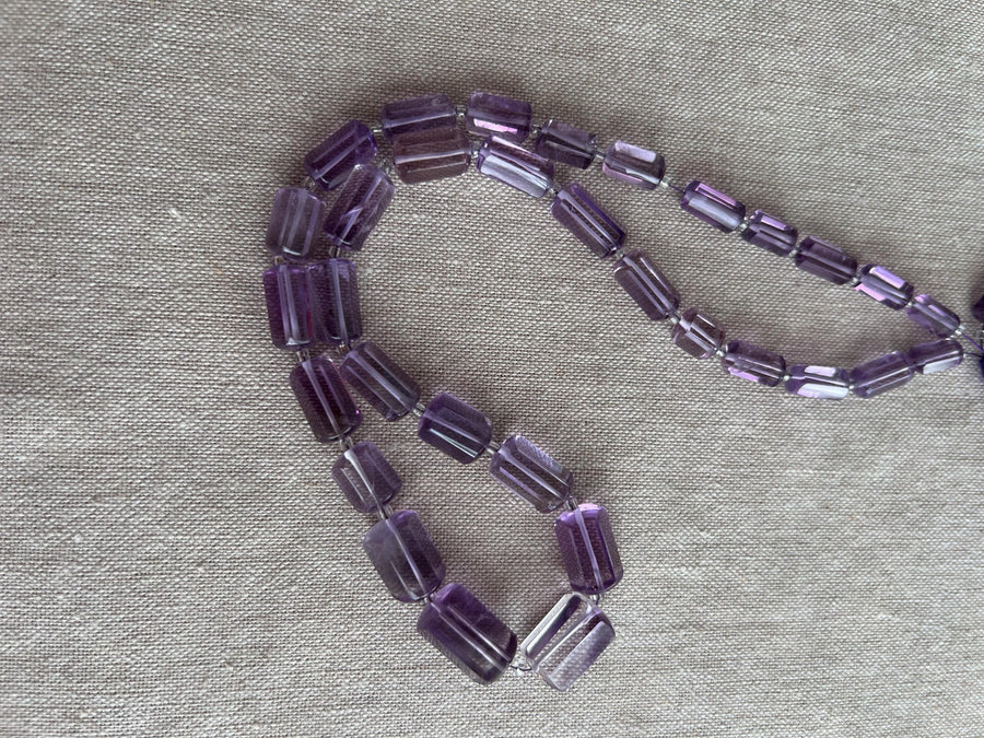 15-inch strand of AAA Brazilian Amethyst faceted cylinder gemstone beads, graduated from 5x10mm to 9x15mm.