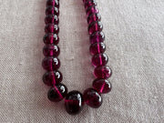 AAA+ untreated Rhodolite Garnet gemstone beads featuring transparent pinkish-purple color, eye-clean clarity, and smooth rondelle cuts.