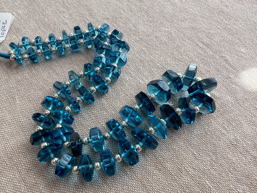 AAA+ Swiss Blue Topaz bolt cut beads featuring uniform vivid blue color, transparent clarity, and distinctive faceted shapes.