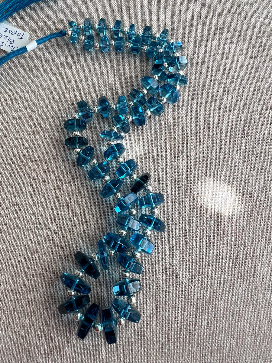 14-inch strand of Swiss Blue Topaz faceted bolt beads, 50 graduated gemstones weighing approximately 206 carats. blue gemstones