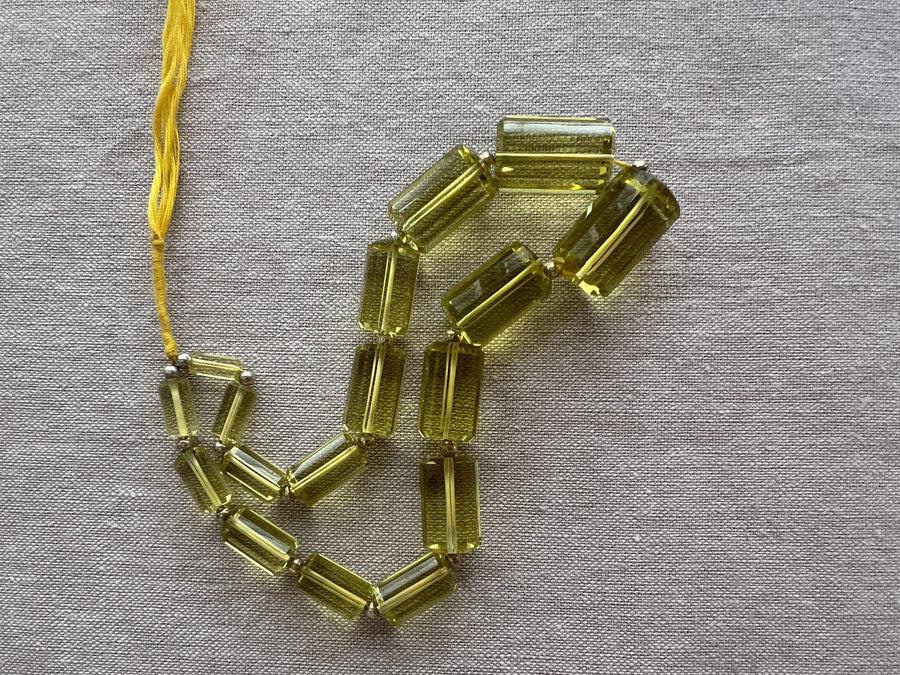 Rare 9-inch strand of 17 graduated Lemon Quartz faceted cylinder beads, ranging from 11x5mm to 20x13mm.