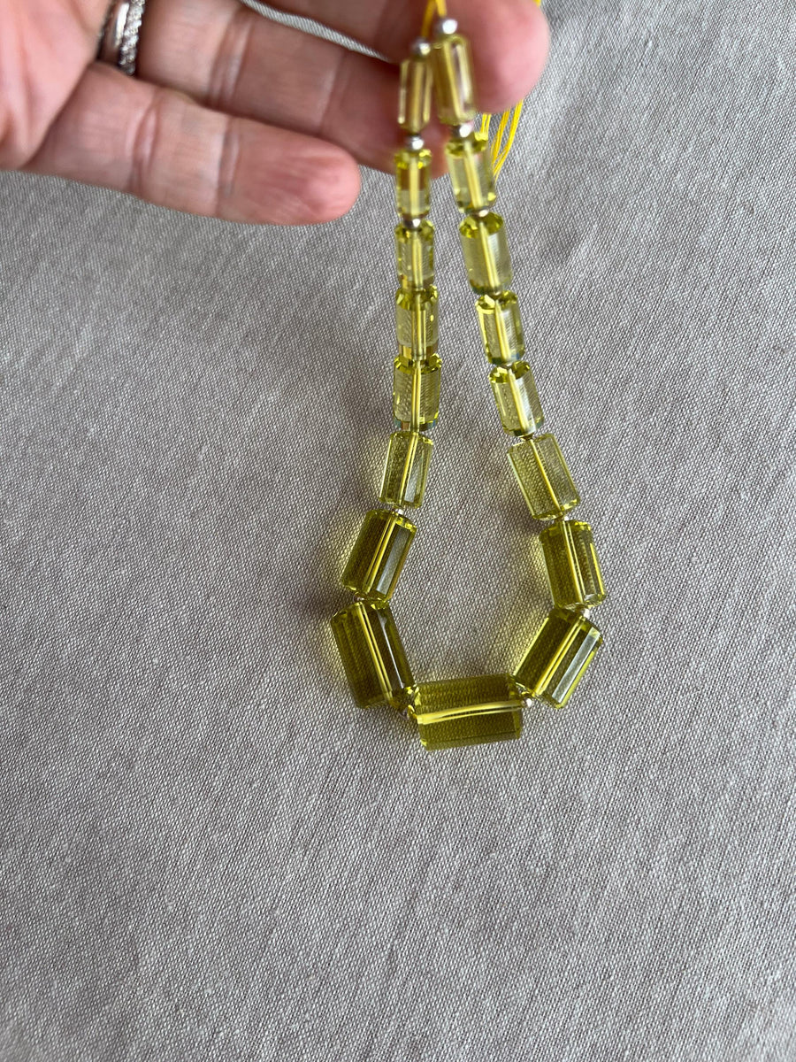 Rare 9-inch strand of 17 graduated Lemon Quartz faceted cylinder beads, ranging from 11x5mm to 20x13mm.