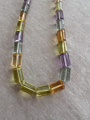 Close-up of AAA++ faceted cylinder gemstone beads showing exceptional transparency, clarity, and sparkling precision-cut facets.