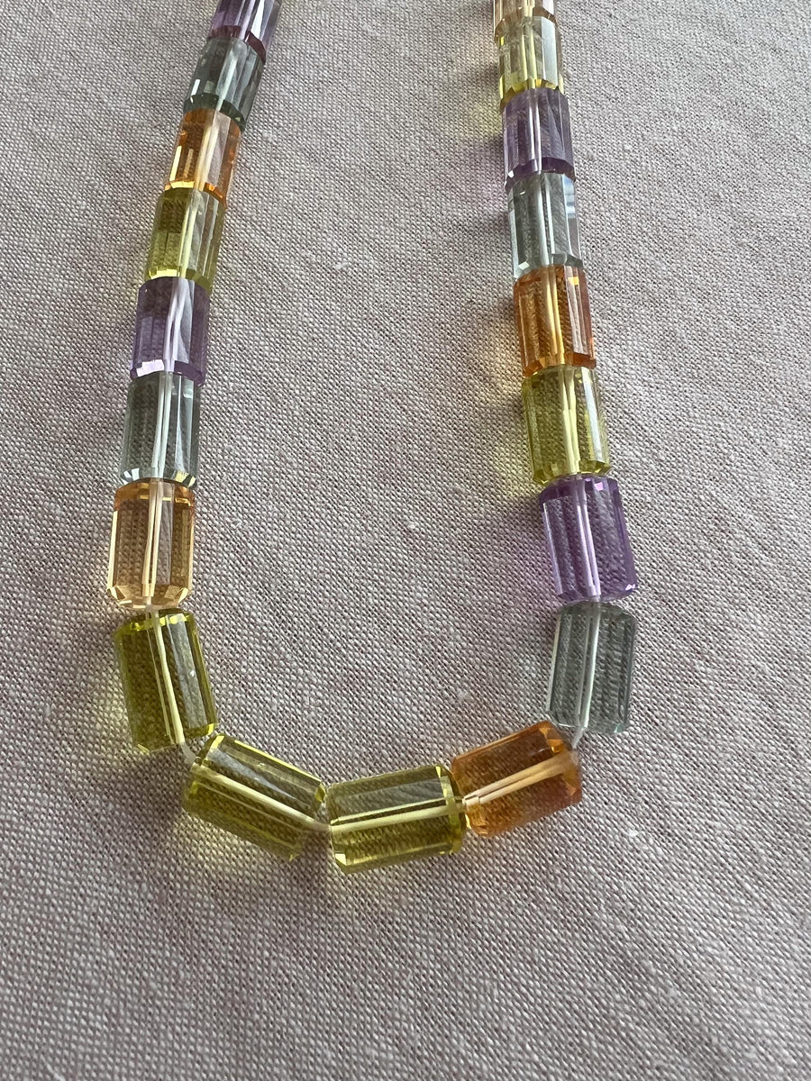 Close-up of AAA++ faceted cylinder gemstone beads showing exceptional transparency, clarity, and sparkling precision-cut facets.