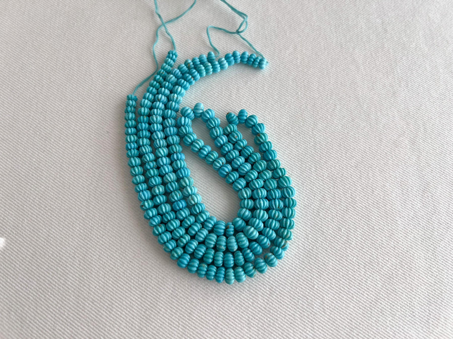 AA+ natural Sleeping Beauty Turquoise carved melon beads from Arizona, featuring classic robin's egg blue color and brown matrix.