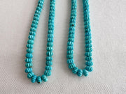 Natural untreated Sleeping Beauty Turquoise beads with distinctive carved pumpkin shapes, blue color, and contrasting brown matrix.