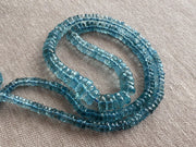 Close-up of transparent Santa Maria Aquamarine beads showing exceptional deep blue color, clarity, and sparkling facets.