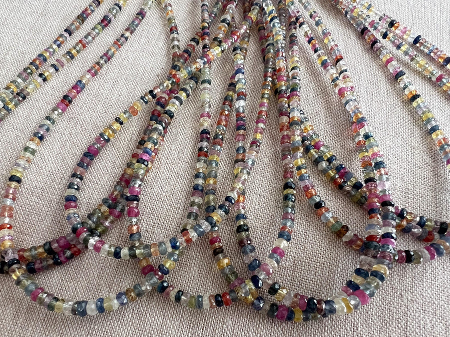 16-inch strand of natural unheated Sapphire faceted rondelle beads in assorted colors, graduated from 2.5mm to 4mm. multiple strands close up image