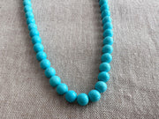 Close-up of 6mm Sleeping Beauty Turquoise round beads showing classic robin's egg blue color and smooth polished surfaces.