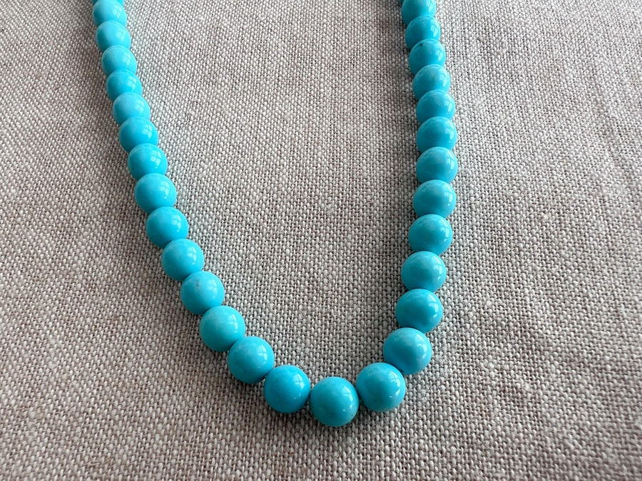 Close-up of 6mm Sleeping Beauty Turquoise round beads showing classic robin's egg blue color and smooth polished surfaces.