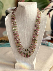 Strand of natural untreated Tourmaline faceted bolt beads in graduated sizes, ideal for fine jewelry making. on a bust