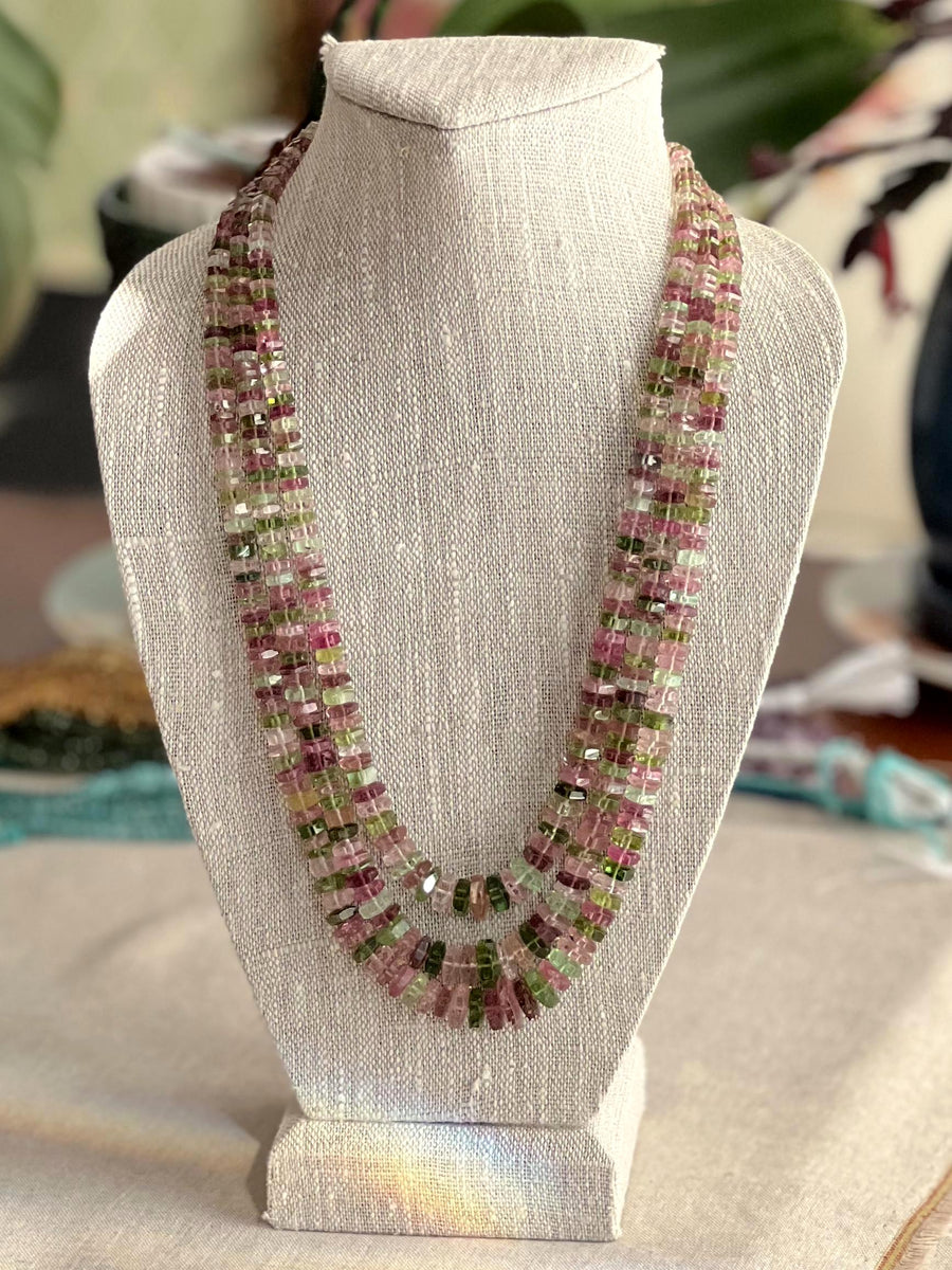Strand of natural untreated Tourmaline faceted bolt beads in graduated sizes, ideal for fine jewelry making. on a bust