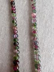 AAA-grade natural bi-color tourmaline smooth rondelle gemstone beads, graduated from 5.5mm to 11mm, featuring beautiful natural color variations for jewelry making. close up image