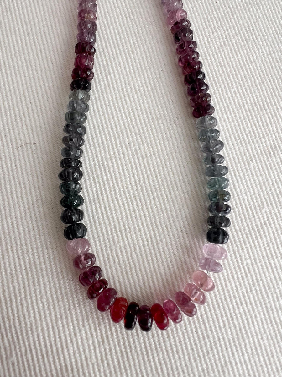Strand of natural multi-color Spinel carved rondelle beads in graduated 5mm–6mm sizes for handmade jewelry. indoor lighting