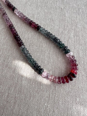 Close-up of AAA carved Spinel rondelle beads showing natural pink, red, and gray gemstone colors.