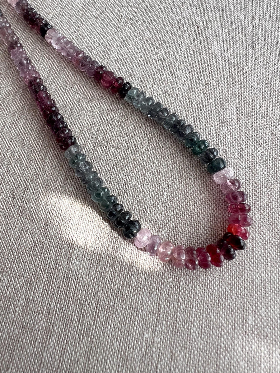 Close-up of AAA carved Spinel rondelle beads showing natural pink, red, and gray gemstone colors.