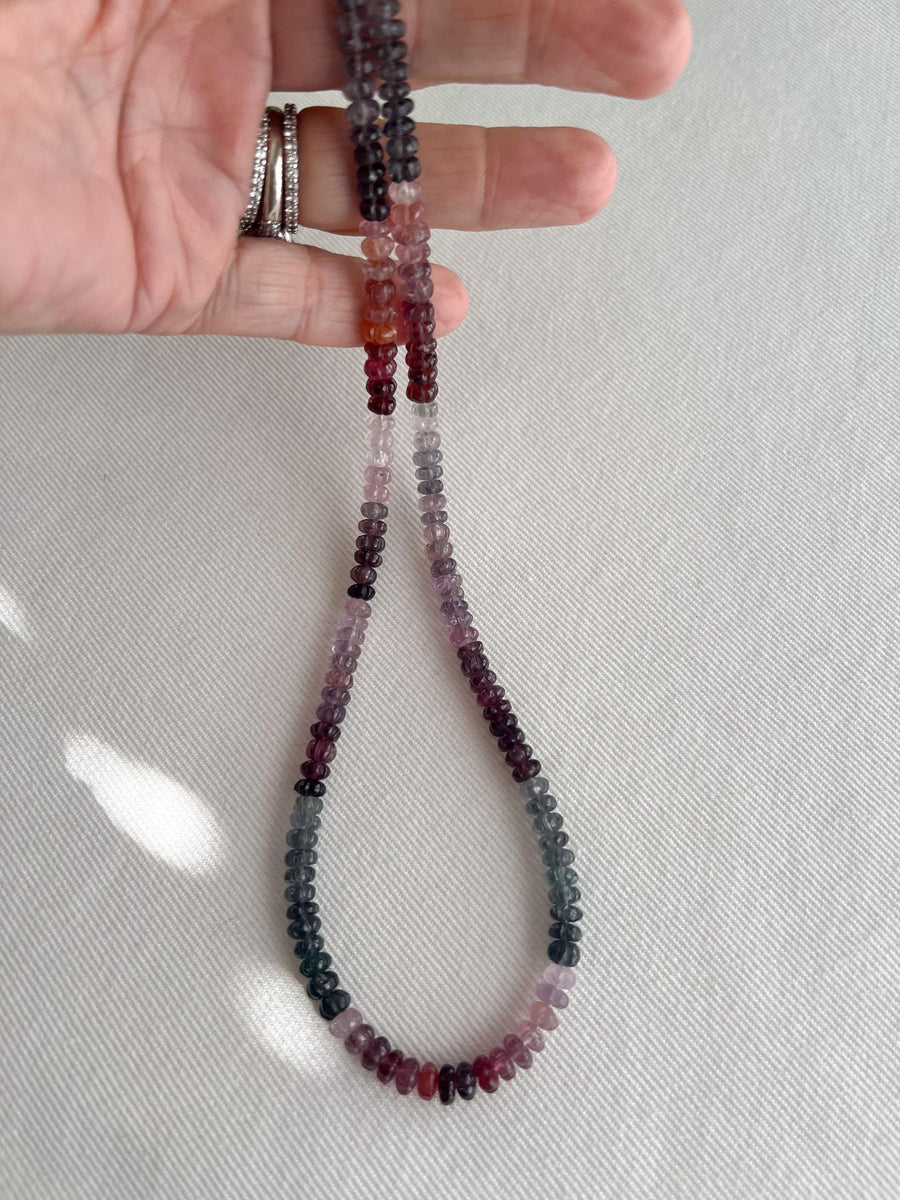 hand holding AAA natural multi-color Spinel carved rondelle gemstone beads, 5mm–6mm, for jewelry making.