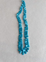 Full strand of AAA natural Sleeping Beauty turquoise smooth almond beads in classic robin's egg blue.