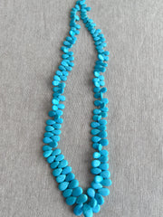 Full strand of AAA natural Sleeping Beauty turquoise smooth almond beads in classic robin's egg blue.