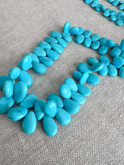 Smooth almond-shaped Sleeping Beauty turquoise beads showing natural Arizona turquoise color and polished surfaces.