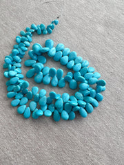 AAA-grade natural Sleeping Beauty turquoise smooth almond-shaped gemstones from Arizona, featuring classic robin's egg blue color and a polished finish.