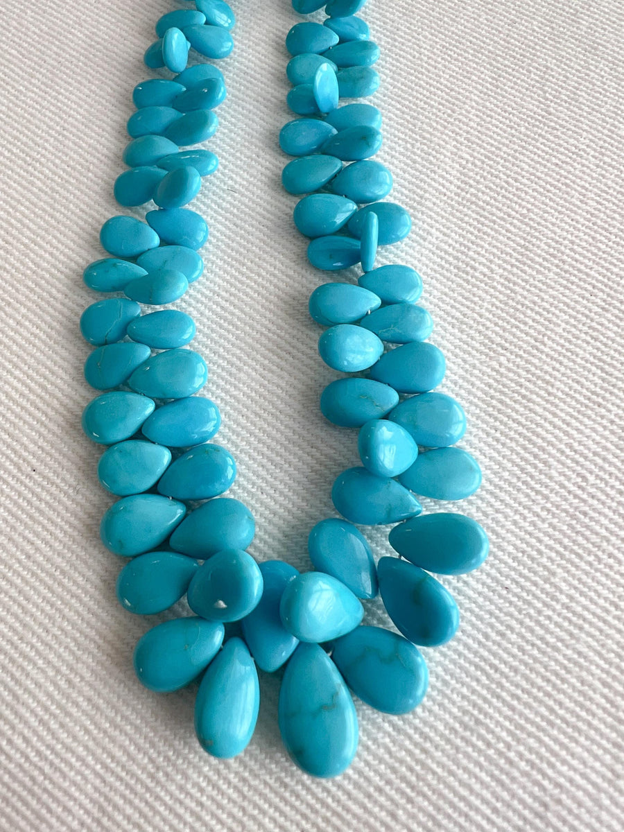 Smooth almond-shaped Sleeping Beauty turquoise beads showing natural Arizona turquoise color and polished surfaces, detail shot