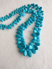 Full strand of AAA natural Sleeping Beauty turquoise smooth almond beads in classic robin's egg blue.
