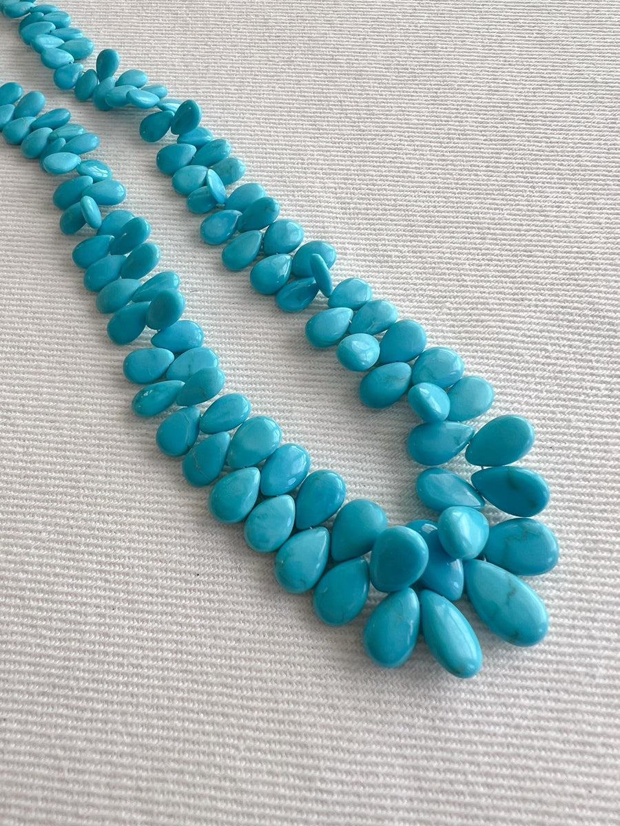 Smooth almond-shaped Sleeping Beauty turquoise beads showing natural Arizona turquoise color and polished surfaces.