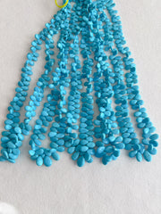 Smooth almond-shaped Sleeping Beauty turquoise beads showing natural Arizona turquoise color and polished surfaces. multiple strands