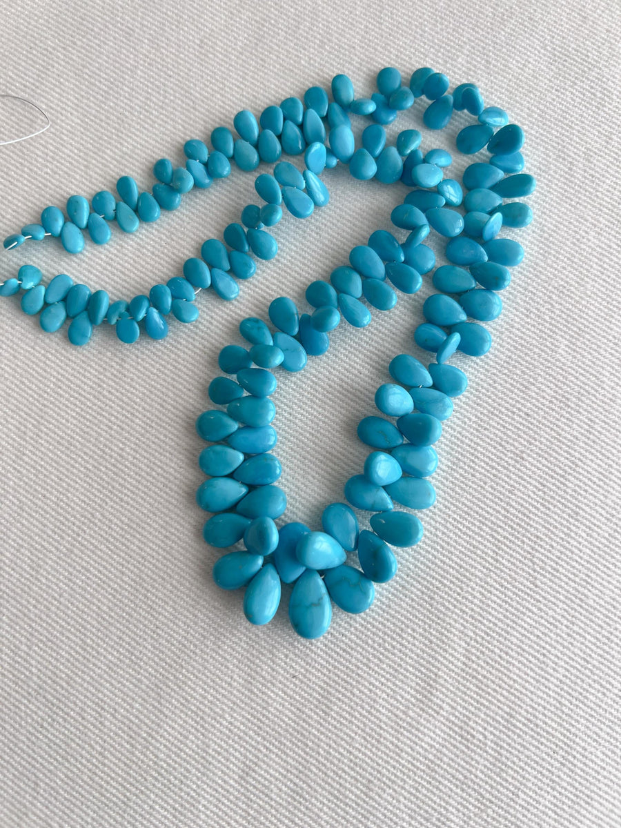 Smooth almond-shaped Sleeping Beauty turquoise beads showing natural Arizona turquoise color and polished surfaces.