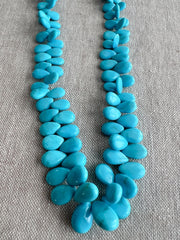 Smooth almond-shaped Sleeping Beauty turquoise beads showing natural Arizona turquoise color and polished surfaces. detail shot